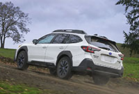 A 2023 Subaru Outback going up a hill on the trail.