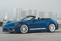 Nové Porsche 911 Carrera GTS Cabriolet America Edition 2023 vypadá úžasně zaparkované před panoramatem města.