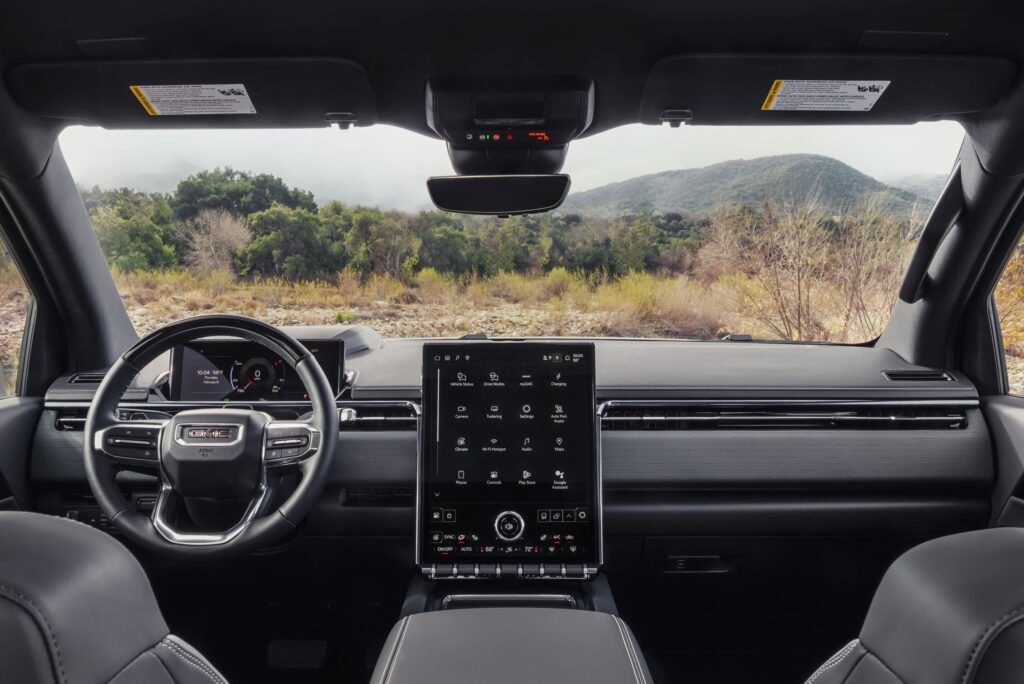 Front-facing interior view of the 2026 GMC Sierra EV AT4 featuring a 16.8-inch-diagonal, portrait-orientation infotainment touch screen.