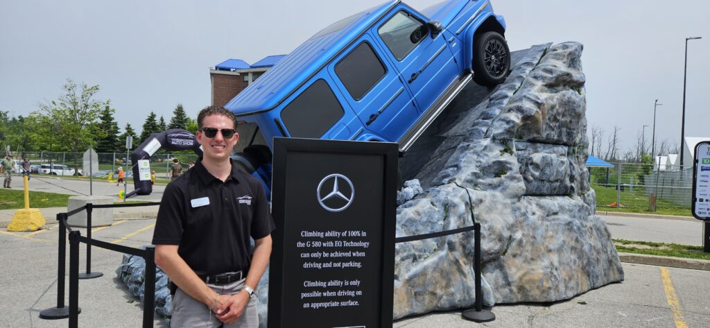 Neven Freyberg Standing In Front Of Mercedes Benz Rock Cliff Display