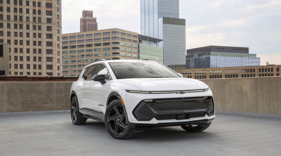 Front 3/4 view of a 2024 Chevrolet Equinox EV RS in Summit White parked on the roof of a parking garage.