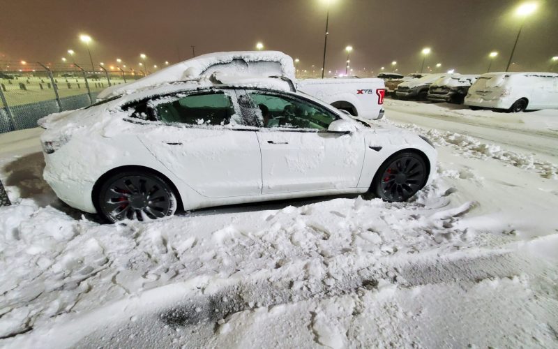 A Tesla Model 3 Performance buried in snow at a Calgary Alberta airport (YYC) parking lot