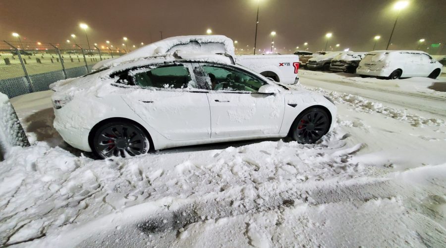 A Tesla Model 3 Performance buried in snow at a Calgary Alberta airport (YYC) parking lot